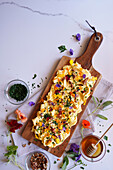 Butter board with herbs, pecans and edible flowers with copy space.