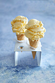 Vanilla ice cream in a cone, in a white ice cream stand, on a blue backround