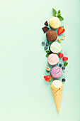 Flying ice cream balls and ingredients on pastel light blue background. Summer minimal concept