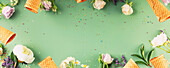 Flat-Lay von Waffeltüten und Blumen auf pastellgrünem Hintergrund, Draufsicht, Flat-Lay. Frühlings- oder Sommerstimmung Konzept, Banner, Copy Space