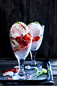 Strawberry ice cream served in a glass and decorated with strawberries