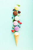 Flying ice cream balls and ingredients on pastel light blue background. Summer minimal concept