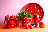 Red fruits and vegetables with red polka dot tableware, colour block aesthetic. Red foods contain powerful, healthy antioxidants, lycopene, anthocyanins and vitamin C, and can boost the immune system.