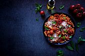 Plant-based, high-protein pasta made from red lentils with roasted vine tomatoes and basil, with negative copy space.