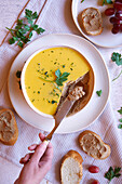 Chicken liver pate served with crusty French baguette bread. Close up with female hand.