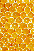 Lots of freshly cut orange slices laid out from above like scales