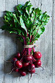 Bunch of fresh beetroots over a gray wooden backround