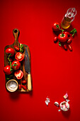 Vine tomatoes on a cutting board in front of a red background