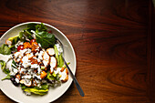 Chicken salad in a bowl on wooden table.