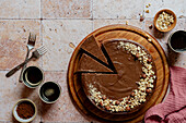 Landscape shot of chocolate cheesecake with hazelnuts and coffee on tiles