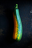 Fresh homemade yellow-green courgette on black metal background