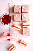 Australian pink lamington Small square cakes with strawberry jam and coconut coating.