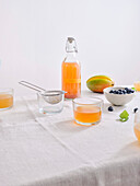 A bottle of homemade fermented kombucha drink with a fruit flavouring on a white background