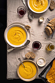 Butternut squash soup bowls on rustic background