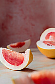 pink sliced pomelo on a pink background