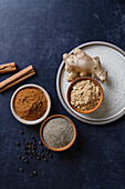 Raw ingredients with their ground spices flatlay onb a blue background