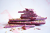 Ruby chocolate made from selected botanical cocoa bean varieties. Dried strawberry and pistachio bark.