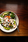 Chicken salad in a bowl on wooden table.