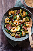 Cajun prawns with zucchini and spicy salami served in a bowl