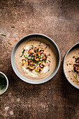 Mushroom soup topped with wild mushrooms on a rustic brown surface