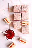 Australischer rosa Lamington Kleiner quadratischer Kuchen mit Erdbeermarmelade und Kokosnussüberzug.