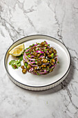 Seaweed salad. Chilean Cebiche de cochayuyo made of chopped cochayuyo seaweed with lemons, cilantro, onions, and salt, white plate, top view