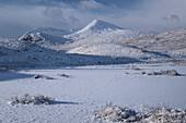 Gefrorener unbenannter Lochan auf Rannoch Moor mit Blick auf Meall a Bhuiridh und Clach Leathad, Rannoch Moor im Winter, Argyll und Bute, Schottische Highlands, Schottland, Vereinigtes Königreich, Europa