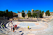 A group of tourists visit the Roman ruins in Arles, a city on the Rhone River, Arles, Bouches-du-Rhone, Provence, France, Europe