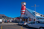 Blick auf bunte Bar und Leuchtturm im Hafen von Hout Bay, Hout Bay, Kapstadt, Westkap, Südafrika, Afrika