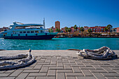 Blick auf ein Boot und die Uferpromenade im Yachthafen von Hurghada, Hurghada, Verwaltungsbezirk Rotes Meer, Ägypten, Nordafrika, Afrika