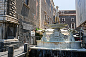 Amenanischer Barockbrunnen mit mythischen Figuren von Tito Angelini, beschriftet mit dem Stadtwappen und einem jungen Mann, der ein Füllhorn hält, Catania, Sizilien, Italien, Mittelmeerraum, Europa