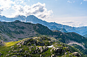 Bergwiese mit einem See auf einem Hochplateau und Blick über hohe Berge mit hoch aufragenden Gipfeln der Schweizer Alpen am Horizont, Schweiz, Europa