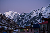 View over Kyanjin Gompa town with soft purple light after sunset and snowy summit of Gangchempo, Lang Tang Valley Trek, Himalayas, Nepal, Asia