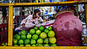 Man resting up  behind his cart of limes, Guwahati, Assam, India, Asia