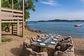 Blick auf einen Esstisch im Freien am Strand von Dassia und dem Ionischen Meer, Dassia, Korfu, Ionisches Meer, Griechische Inseln, Griechenland, Europa