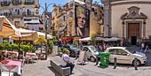 Blick auf Cafés und San Gennaro di Jorit Agoch in der belebten Via Forcella, Neapel, Kampanien, Italien, Europa