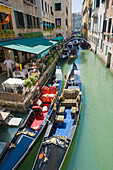 Two elegant gondolas moored in front of a restaurant along a narrow canal leading off the Grand Canal, Venice, UNESCO World Heritage Site, Veneto, Italy, Europe