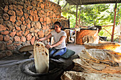 Frau bei der Zubereitung von Lavash (dünnes, ungesäuertes Fladenbrot) in einem Tandoor, auf Armenisch Tonir genannt, in einem Restaurant neben dem Noravank-Kloster, nahe Yeghegnadzor, Armenien, Eurasien