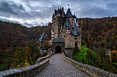 Eltz mittelalterliche historische Burg in einer Herbstlandschaft mit Bäumen bei Sonnenaufgang, Wierschem, Rheinland-Pfalz, Deutschland, Europa