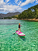 Mädchen auf einem SUP in den türkisfarbenen Gewässern der Halbinsel Formentor, Mallorca, Balearen, Spanien, Mittelmeer, Europa