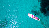 Aerial of a young girl paddling on a SUP on the Formentor Peninsula, Mallorca, Balearic islands, Spain, Mediterranean, Europe