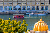 Touristenboot auf dem Pichola-See mit dem Stadtpalast im Hintergrund, Udaipur, Rajasthan, Indien, Südasien, Asien