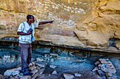 Führer, der auf antike Felsmalereien in der prä-aksumitischen Siedlung von Qohaito (Koloe), Eritrea, Afrika, hinweist