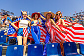 Patriotische amerikanische Frau springt und jubelt für das Team USA und die Olympischen Spiele Paris 2024 vor dem Eiffelturm, Paris, Frankreich, Europa