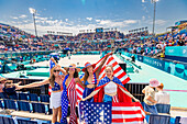 Patriotische amerikanische Frau springt und jubelt für das Team USA und die Olympischen Spiele Paris 2024 vor dem Eiffelturm, Paris, Frankreich, Europa