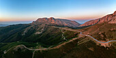 Drohnen-Panoramablick auf ein Wohnmobil auf einer Bergstraße bei Sonnenuntergang, Sardinien, Italien, Mittelmeer, Europa