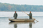 Zwei Fischer auf einem Boot bereiten sich auf die Fischernte vor, Rozmberk-Teich, UNESCO-Biosphäre, Trebon, Bezirk Jindrichuv Hradec, Südböhmische Region, Tschechische Republik (Tschechien), Europa