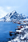 Dusk over the traditional fishing village of Reine after snowfall, Reine, Lofoten Islands, Norway, Scandinavia, Europe