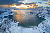 Winterliche Luftaufnahme eines mit Schnee bedeckten Strandes bei Sonnenuntergang, Vik Strand, Vestvagoy, Lofoten, Norwegen, Skandinavien, Europa