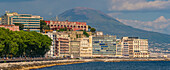 Blick auf pastellfarbene Architektur, Restaurants und Cafés an der Uferpromenade der Via Partenope und den Vesuv, Neapel, Kampanien, Italien, Europa